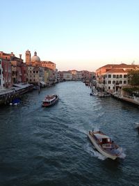 Boats in river with buildings in background