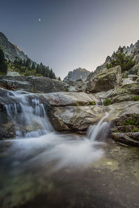 Scenic view of waterfall against sky