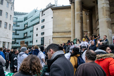 People on street against buildings in city