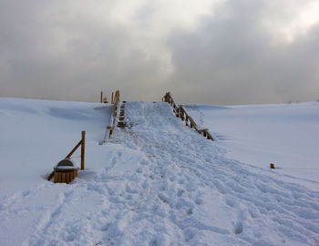 Scenic view of snow covered field against sky