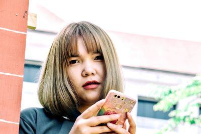 Close-up portrait of woman using mobile phone