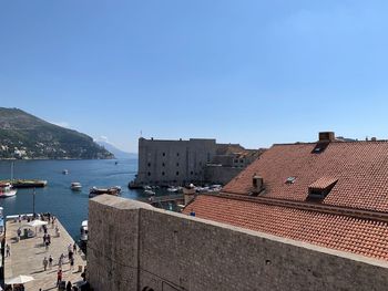 High angle view of townscape by sea against clear sky