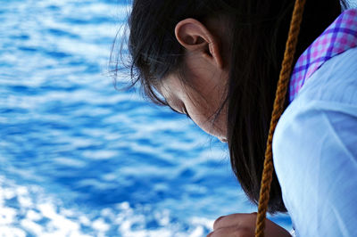 Close-up of woman looking down at sea