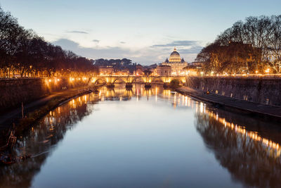 Tiber river and in the background the basilica of san pietro, in a panoramic view at the sunset.