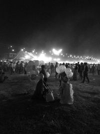 Crowd in front of illuminated park at night