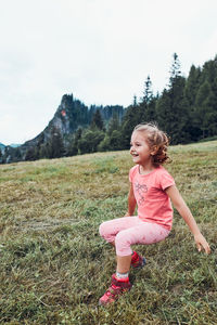 Little girl laying playing on grass enjoying summer day. happy child playing in the field