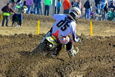 Rear view of man riding motorcycle on dirt