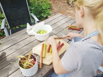 High angle view of woman holding food on table