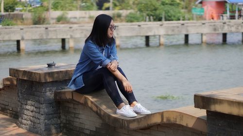 Side view of young woman sitting on steps