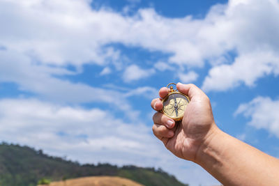 Midsection of woman holding hands against sky