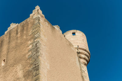 Low angle view of old building against blue sky