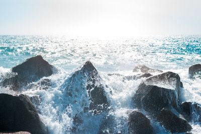 Waves splashing on rocks in sea