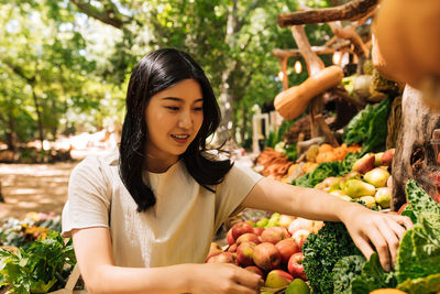 Portrait of young woman holding fruits