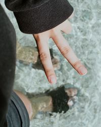 High angle view of hand gesturing over water