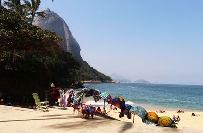 People on beach against clear sky