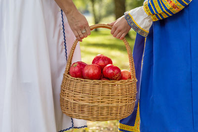 Close-up of hand holding strawberries in basket