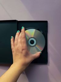 The hand takes the cd out of the case