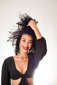 Portrait of young beautiful smiling woman with hand in hair. 