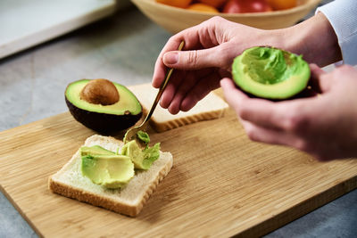 Ripe avocado in woman hands, healthy breakfast