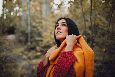 Young woman looking away in forest