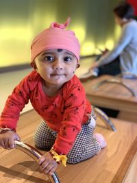 Portrait of cute baby sitting on bench