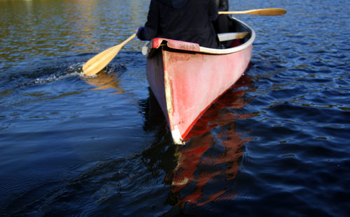 Midsection of person rowing boat in lake