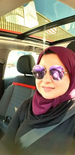 Portrait of a smiling young woman sitting in car