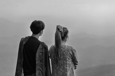 Rear view of group people standing against sky