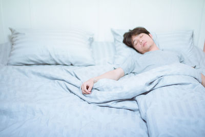 Young woman sleeping on bed at home