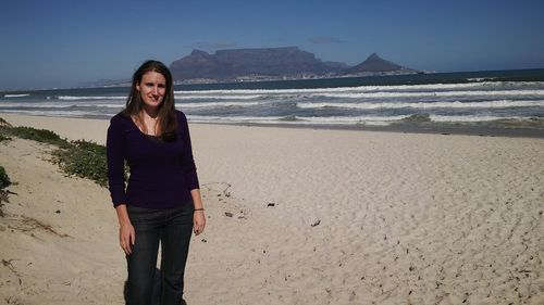 Portrait of young woman standing at beach