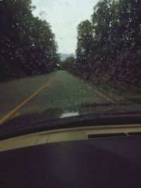 Road seen through wet windshield during rainy season