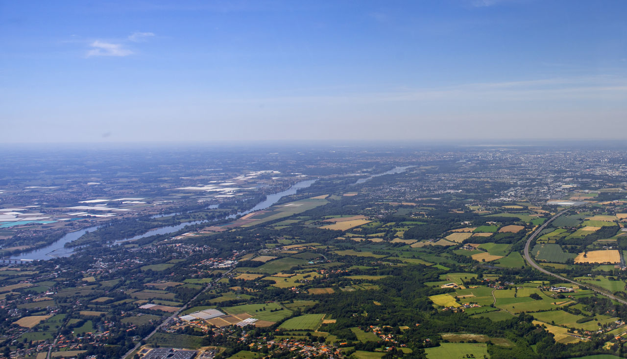 AERIAL VIEW OF CITY AND TREES ON FIELD AGAINST SKY