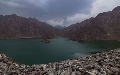 Scenic view of lake by mountains against sky