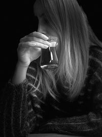 Woman holding drink in dark