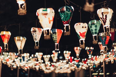 Close-up of illuminated lanterns hanging at market stall