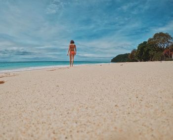 Rear view of woman walking on beach