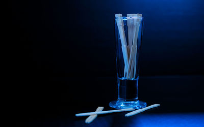 Close-up of glass on table against black background