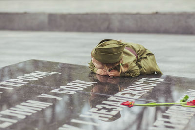 Baby girl in soviet military uniform leaned against the stele to those killed in world war ii

