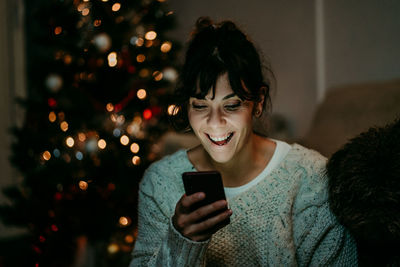 Young woman using mobile phone at home