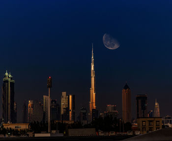 Modern buildings against sky at night