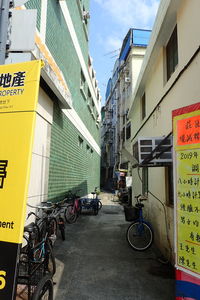 Bicycle parked on street amidst buildings in city