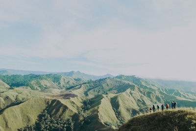 High angle view of people hiking mountain against sky