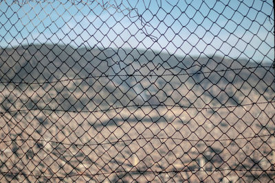 Full frame shot of chainlink fence against sky