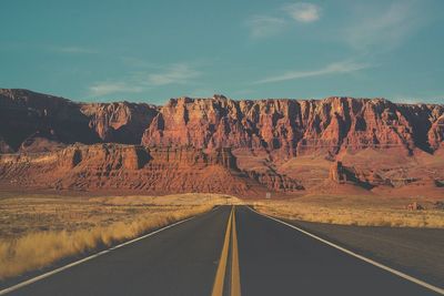 Road amidst rock formations against sky