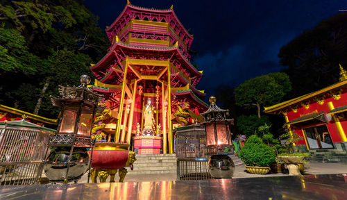 Illuminated temple building against sky at night