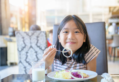 Portrait of a smiling woman sitting in restaurant