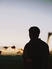 Rear view of silhouette man looking at sunset