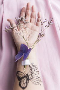 Hand with flowers and tattoo