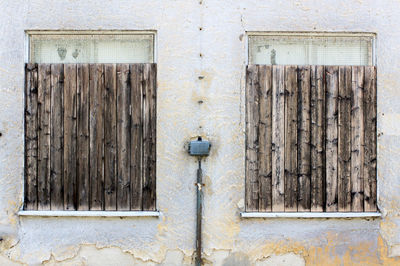 Old closed windows on weathered wall