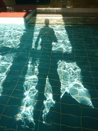 Reflection of man in swimming pool